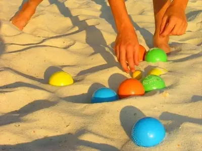 a person playing with colored eggs in the sand at the Newport Family Peninsula Beach House in Newport Beach