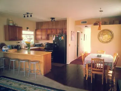 a kitchen with a table and a black refrigerator at the Newport Family Peninsula Beach House in Newport Beach