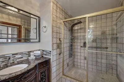 a bathroom with a shower and a sink and a mirror at Elevado Hills Family Getaway ~ Pool ~ Games ~ Pkg! in Vista