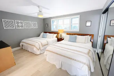 a bedroom with two beds with white sheets at Ocean View Luxury Condo Oceanfront and Pool in San Diego