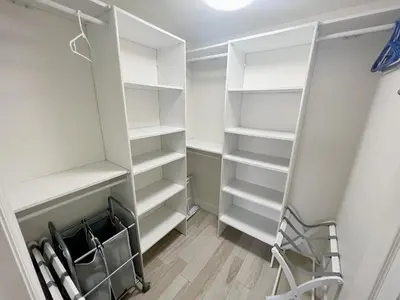a walk in closet with white shelves and a ladder at Ocean View Luxury Condo Oceanfront and Pool in San Diego