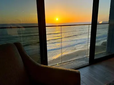 a view of a sunset from a room with a window at Ocean View Luxury Condo Oceanfront and Pool in San Diego