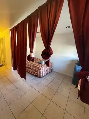 a living room with red curtains and a couch at Crown Inn & Suites in Spring Valley