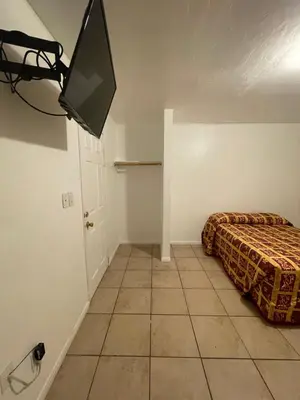 a bedroom with a bed and a tv in it at Crown Inn & Suites in Spring Valley