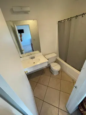 a bathroom with a sink and a toilet and a mirror at Crown Inn & Suites in Spring Valley