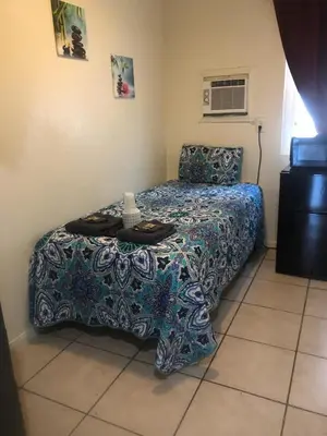 a small bedroom with a bed and a table at Crown Inn & Suites in Spring Valley