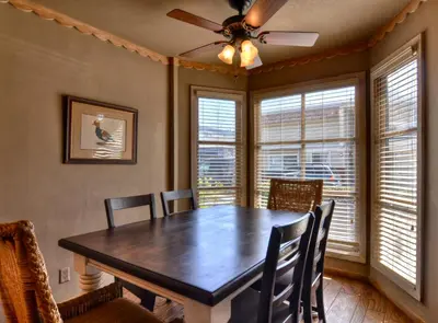 a dining room with a table and chairs and windows at 201 Ruby in Newport Beach