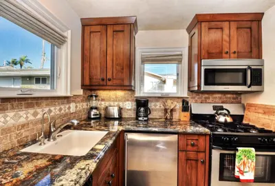 a kitchen with wooden cabinets and a sink and a microwave at Villa D'Arte at the Retreat in Laguna Beach in Laguna Beach