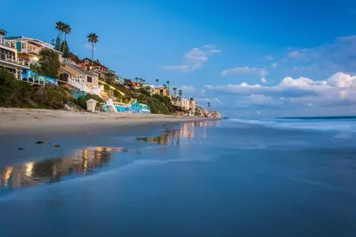a beach with houses and palm trees and the ocean at Villa Da Vinci at the Retreat at Laguna Beach in Laguna Beach