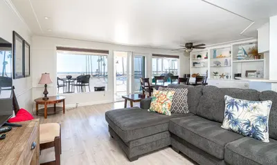 a living room with a gray couch and a dining room at 1005 E Balboa 2 in Newport Beach