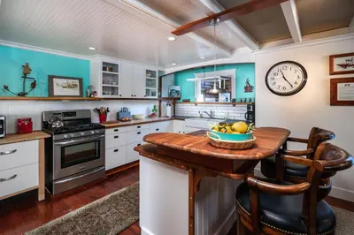 a kitchen with a table and a clock on the wall at 318 Lindo Ave in Newport Beach