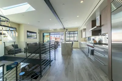 a kitchen with wooden floors and stainless steel appliances at 501 E Bay Ave in Newport Beach