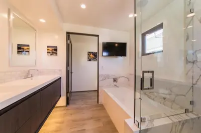 a bathroom with two sinks and a tub and a shower at 501 E Bay Ave in Newport Beach