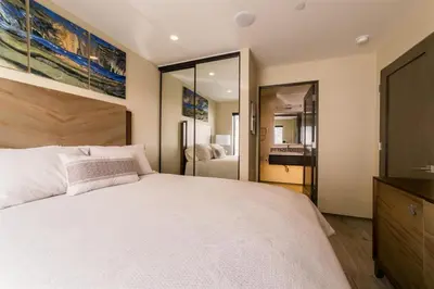 a bedroom with a large white bed and a mirror at 501 E Bay Ave in Newport Beach