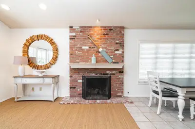 a living room with a brick fireplace and a table at 210 Opal Ave Front House in Newport Beach
