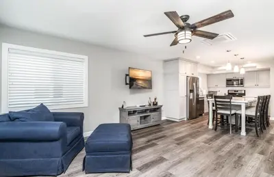 a living room with a blue couch and a ceiling fan at 129 Opal Ave A in Newport Beach