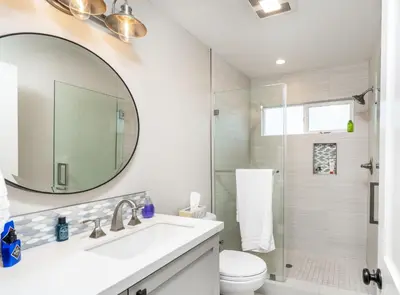 a white bathroom with a sink and a shower at 129 Opal Ave B in Newport Beach