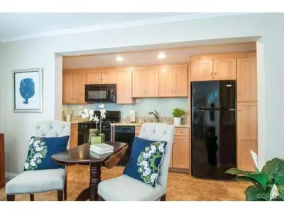 a kitchen with a table and chairs and a black refrigerator at 313 E Bay Ave A & B in Newport Beach