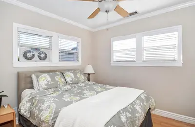 a bedroom with a bed and two windows at 313 E Bay Ave A & B in Newport Beach