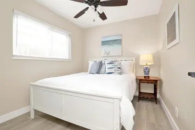 a bedroom with a white bed and a ceiling fan at 114 Forty Second Street A and B in Newport Beach