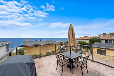 a patio with a table and chairs and an umbrella at Villa Teatro at the Retreat in Laguna Beach in Laguna Beach