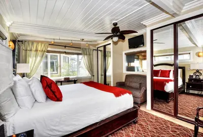 a bedroom with a large bed and a living room at Villa Roma at the Retreat in Laguna Beach in Laguna Beach