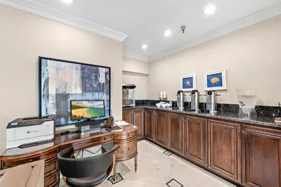 a living room with a large television and a desk at Villa Lanai at the Sunset Cove Villas in Laguna Beach