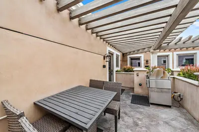 a patio with a wooden table and chairs at Villa Lanai at the Sunset Cove Villas in Laguna Beach