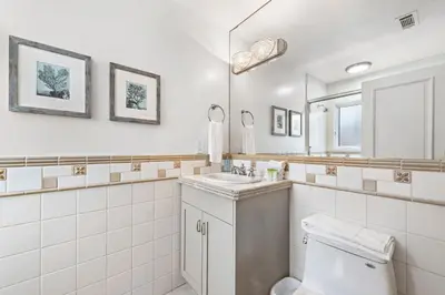 a bathroom with a toilet and a sink and a mirror at Villa Lanai at the Sunset Cove Villas in Laguna Beach
