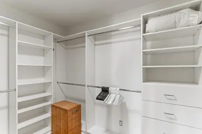 a walk in closet with white shelves and a wooden box at Luxury Beach House. Pool/Hot Tub! Walk to Beach! in Carlsbad