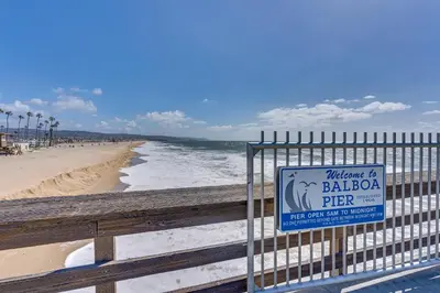 a sign on a fence next to the beach at Newport Beach Vacation Rental Steps to Shore! in Newport Beach