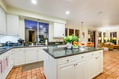 a kitchen with white cabinets and granite counter tops at 1 Mi to the Beach! Ocean-View Encinitas Home in Encinitas