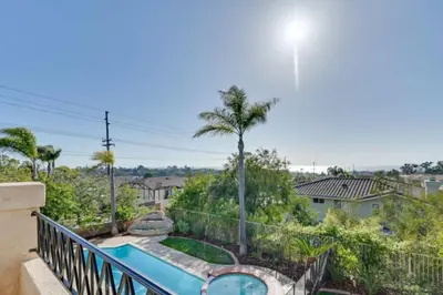 a balcony with a swimming pool and palm trees at 1 Mi to the Beach! Ocean-View Encinitas Home in Encinitas