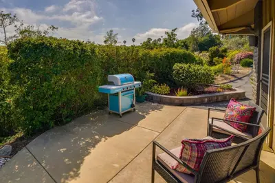 a blue grill sitting on a patio next to two chairs at Fallbrook Home with Mountain Views Close to Hiking! in Fallbrook