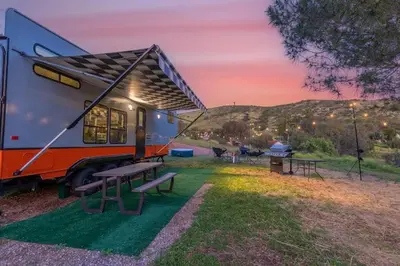 a rv with a picnic table and a grill at Harley Davidson Ranch Glampling With Kids Play Zone in Ramona