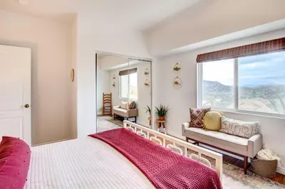 a bedroom with a large bed and a mirror at Mountaintop Ramona Home Private Pool, Near Lake! in Ramona